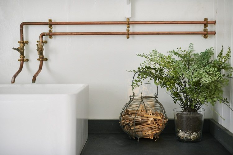 Les qualités esthétiques des tuyaux en cuivre permettent l'utilisation de tuyaux d'eau ordinaires comme un détail intérieur dans un certain style Tuyaux et raccords en cuivre pour l'alimentation en eau